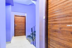 a hallway with a wooden door and a staircase at Super Collection O New Town Near OM Sweets Formerly Shiva Inn in kolkata +36 photos
