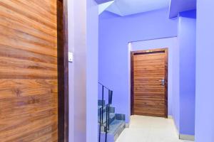 a hallway with blue walls and a wooden door at Super Collection O New Town Near OM Sweets Formerly Shiva Inn in kolkata