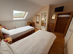 a hotel room with two beds and a window at Kerry Ocean Lodge Room only in Glenbeigh