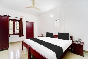 a bedroom with a large bed in a room at Super Hotel O Sultan Bathery Formerly Bluevalley in Wayanad