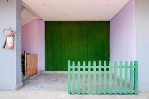 a green wall in a room with a fence at Hotel O Garchuk Market Formerly Trendz Stay in Guwahati