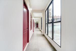 a corridor of a building with large windows at Super Hotel O Sultan Bathery Formerly Bluevalley in Wayanad