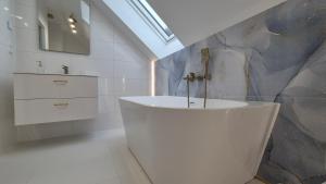 a bathroom with a bath tub and a sink at Apartamenty Bujowy in Ustroń +34 photos