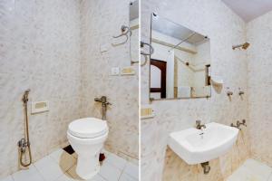 a bathroom with a toilet and a sink and a mirror at Super Townhouse Calangute Formerly Hotel Horizon in Goa