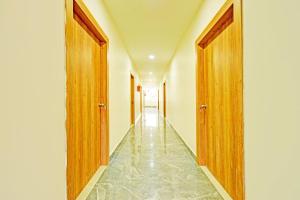 a hallway with two wooden doors and a tile floor at Super Townhouse Oak Kompally in Hyderabad
