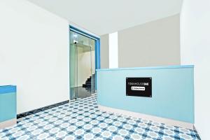 an empty lobby with a blue wall and checkered floor at Super Townhouse Oak Kompally in Hyderabad
