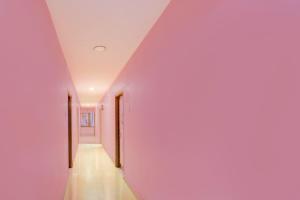 a hallway with pink walls and a white ceiling at Collection O Victoria Memorial Metro Station Formerly Shanthaa Residency in Surūrnagar