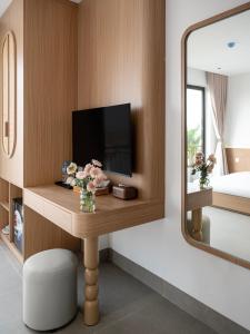 a room with a tv and a mirror at Solla Hotel in Ninh Binh