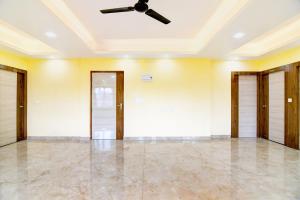 an empty room with a ceiling fan and doors at Super Townhouse Rosedale Formerly Reliance Guest House in Kolkata