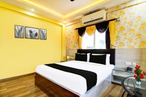 a bedroom with a large white bed and a window at Super Townhouse Rosedale Formerly Reliance Guest House in Kolkata