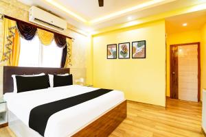 a bedroom with a large white bed and a window at Super Townhouse Rosedale Formerly Reliance Guest House in Kolkata