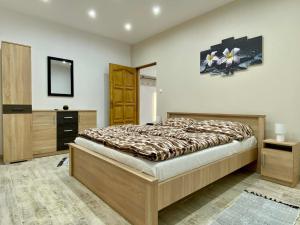 a bedroom with a bed and a dresser and a mirror at Tündi Vendégház in Balatonlelle