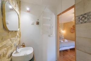 a bathroom with a sink and a mirror and a bedroom at Chambres D’hôtes - Les Agrions in Saint-Remèze