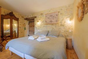 a bedroom with a bed with towels on it at Chambres D’hôtes - Les Agrions in Saint-Remèze