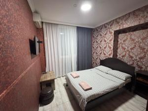 ein kleines Schlafzimmer mit einem Bett in einem Zimmer in der Unterkunft Hotel VENUS in Tbilisi City