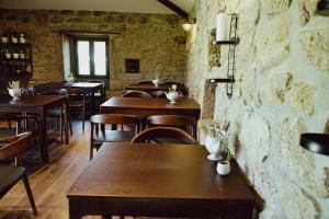 a restaurant with wooden tables and chairs and a brick wall at Casa d'Amares in Amares