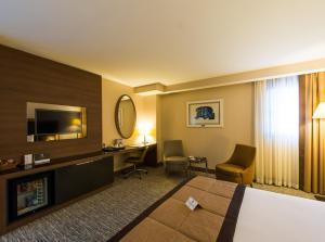 a hotel room with a bed and a desk at Hotel Sky Nest Suites Near IGI Airport Delhi in New Delhi