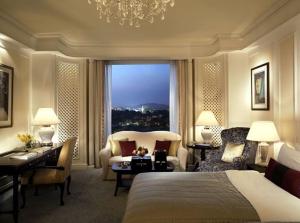 a hotel room with a bed and a desk and a window at Hotel Sky Nest Suites Near IGI Airport Delhi in New Delhi
