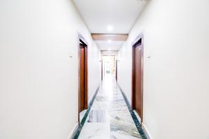 a corridor of an empty room with white walls and wooden doors at OYO Hotel O Gurudwara Near RTC Complex in Visakhapatnam