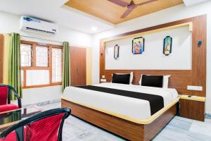 a bedroom with a bed and a red chair at OYO Hotel O Gurudwara Near RTC Complex in Visakhapatnam +42 photos