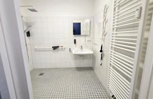 a white bathroom with a sink and a mirror at Liro Apartments Düsseldorf in Düsseldorf