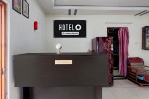 a counter in a room with a hotel sign on the wall at OYO Hotel O Benz Circle Vijayawada in Vijayawāda