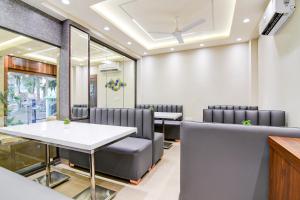 a waiting room with a table and chairs at Super Townhouse Kaikhali Near Airport in Kolkata
