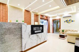 a lobby with a hotel sign on a marble counter at Super Townhouse Kaikhali Near Airport in Kolkata