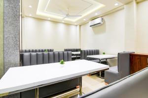 a conference room with tables and chairs and a ceiling at Super Townhouse Kaikhali Near Airport in Kolkata +43 photos