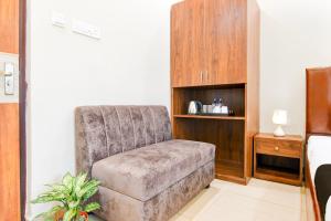 a living room with a chair and a table at Super Townhouse Kaikhali Near Airport in Kolkata
