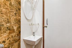 a bathroom with a sink and a mirror at Super Townhouse Kaikhali Near Airport in Kolkata