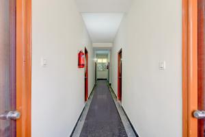 a hallway with white walls and a long aisle at Super Collection O Forum Mall Hyderabad Formerly Ruby Grand Inn in Kondapur +34 photos