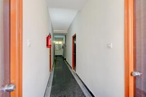 a hallway with a long corridor with a red fire extinguisher at Super Collection O Forum Mall Hyderabad Formerly Ruby Grand Inn in Kondapur