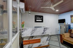 a lobby with a marble counter and a sign on the wall at Super Collection O Forum Mall Hyderabad Formerly Ruby Grand Inn in Kondapur