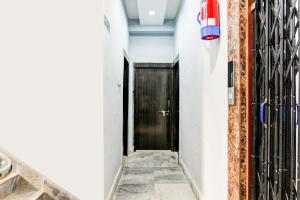 a hallway with a black door and a tile floor at Super Hotel O Narayana RN Tagore Hospital Formerly Lantern Guest House in Jādabpur