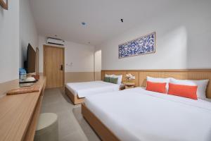 a hotel room with two beds and a television at Solla Hotel in Ninh Binh