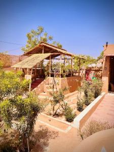 a building with a wooden structure in a garden at VVIP Gajban Resort & Desert Stay, Bikaner in Bikaner