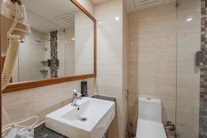 a bathroom with a sink and a toilet and a mirror at The India Benares in Varanasi +73 photos