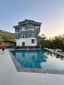 a building with a swimming pool in front of a building at Taşhan Apart Otel in Didim