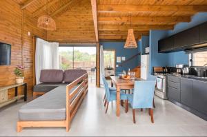 a kitchen and dining room with a table and a couch at Casa com Banheira, Piscina e Quadra de Areia in Praia do Rosa