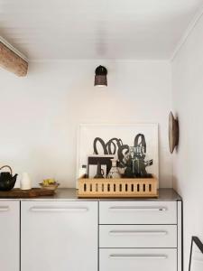 a kitchen with white cabinets and a shelf with items on it at Historic Vipp House From 1775 In Søllested in Søllested