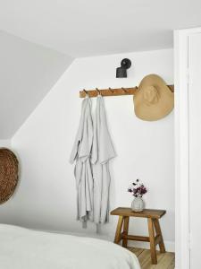 a bedroom with white walls and a bed and a table at Historic Vipp House From 1775 In Søllested in Søllested +8 photos