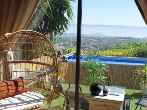 a rattan chair sitting on a balcony with a view at צימר תומר דבורה-קצה ההר in Kerem Ben Zimra