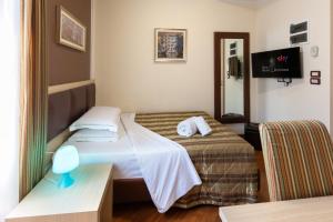 ein kleines Zimmer mit einem Bett und einem Spiegel in der Unterkunft New Hotel Dulcinea in Muggia