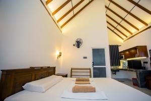 a bedroom with a bed with two towels on it at Ceylon Princes Villa in Ahangama