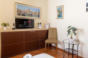 ein Wohnzimmer mit einem Schrank und einem Stuhl in der Unterkunft New Hotel Dulcinea in Muggia + 11 Fotos