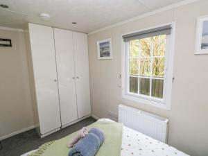 a bedroom with a bed and a window at Meadows Farm Lodge in Swansea
