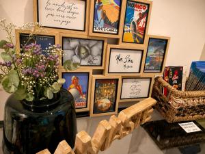 a bunch of pictures on a wall with a vase with flowers at Chambre Confort Premium - Monaco 1 in Beausoleil