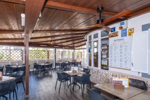 a restaurant with tables and chairs and a menu on the wall at Apartamentos Sol Ponent in Cala Blanca
