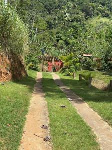 a dirt road in the middle of a grass field at Chácara nosso pedacinho do céu in Domingos Martins